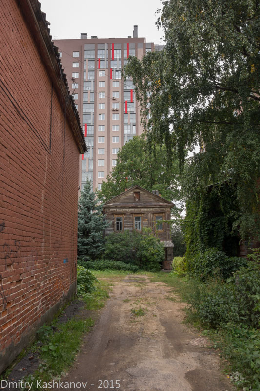 Деревянный дом 111 на фоне современного. Улица Ильинская